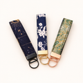 Green patterned fabric with rose-gold-tone hardware. This listing is for the right wristlet shown in the photo.